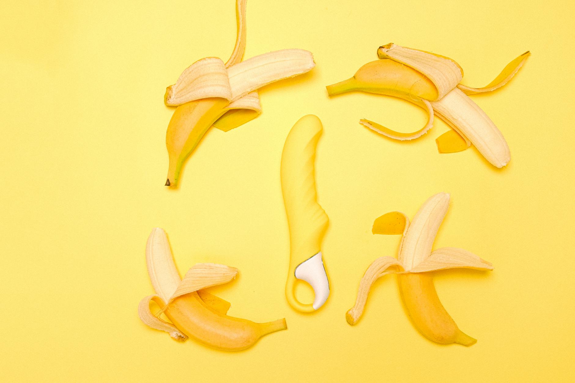Lemon clitoral vibrator surrounded by fresh lemons on a yellow background