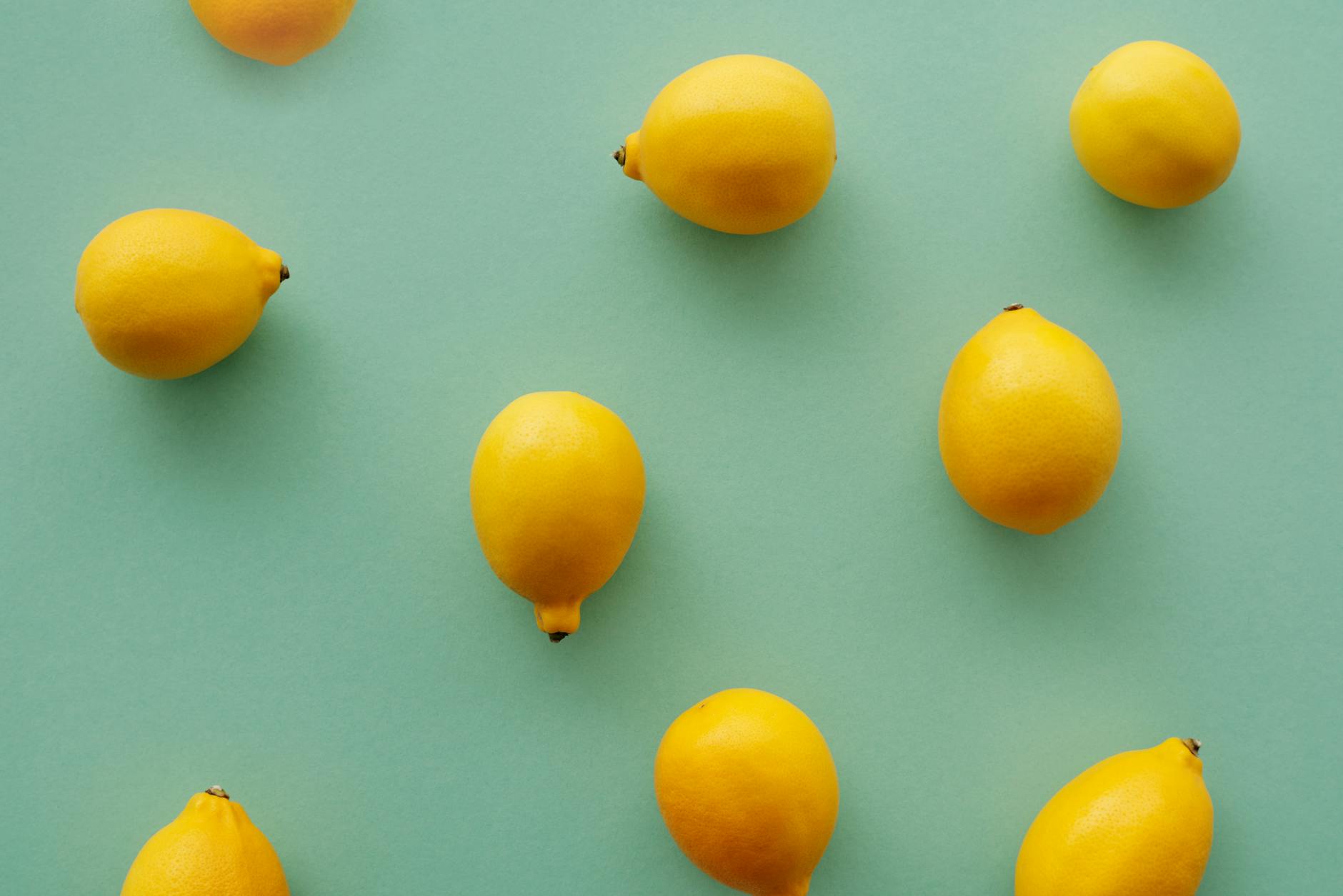 Bright yellow lemons on a soft pastel green background, symbolizing fresh starts and renewed vitality