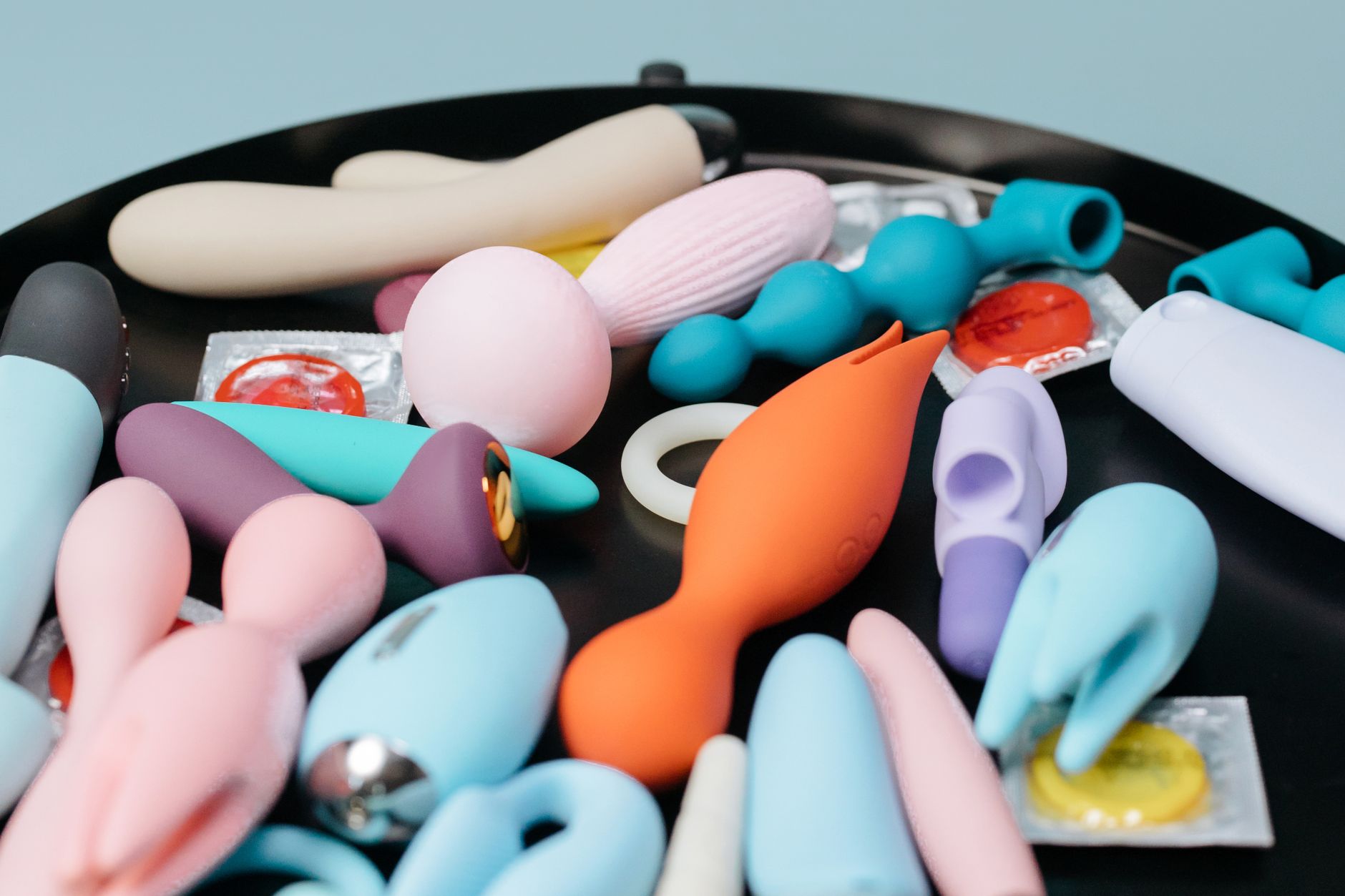 A collection of colorful lemon vibrators and adult toys arranged on a black surface