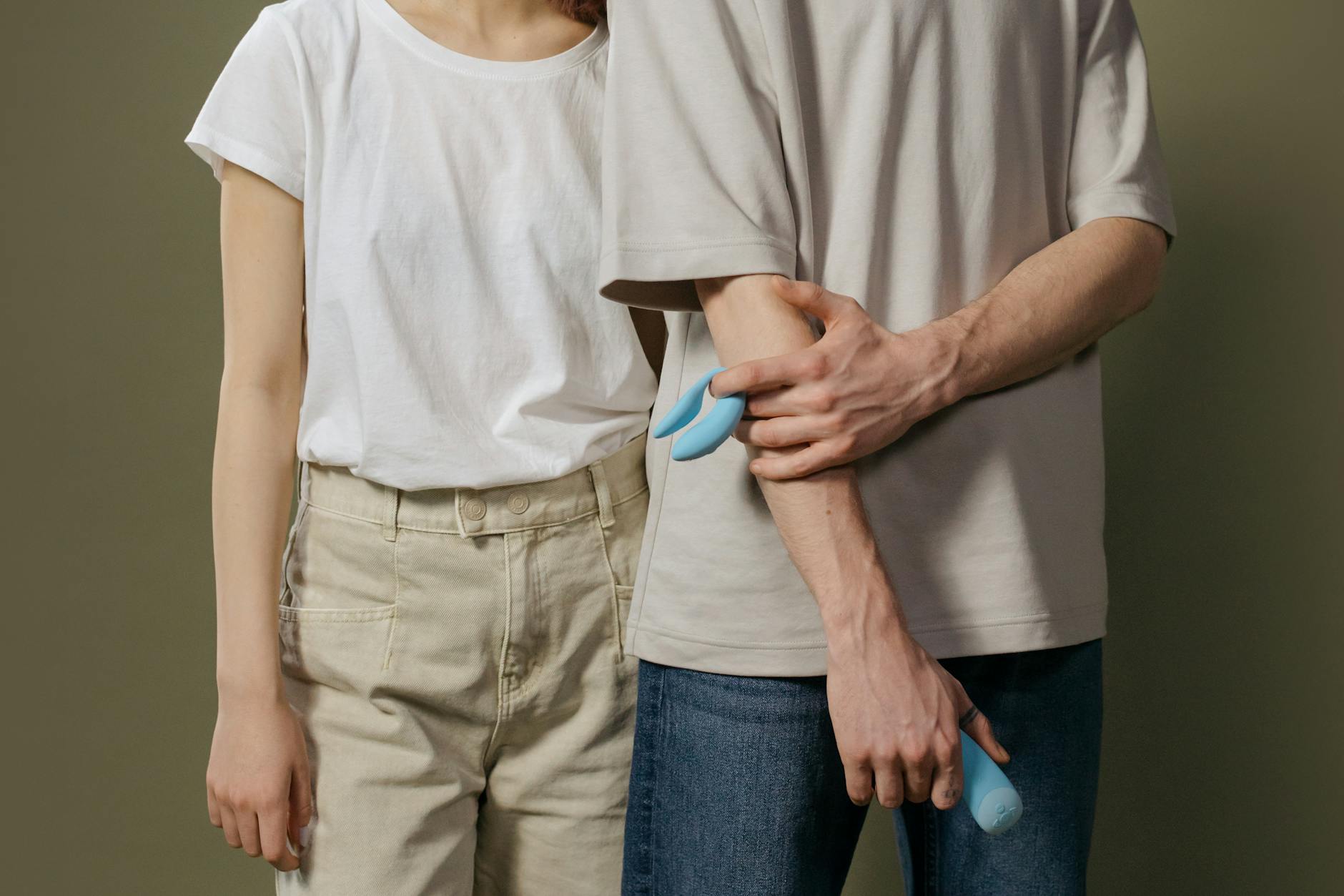 A couple standing together indoors, exploring intimacy and pleasure with a vibrator.