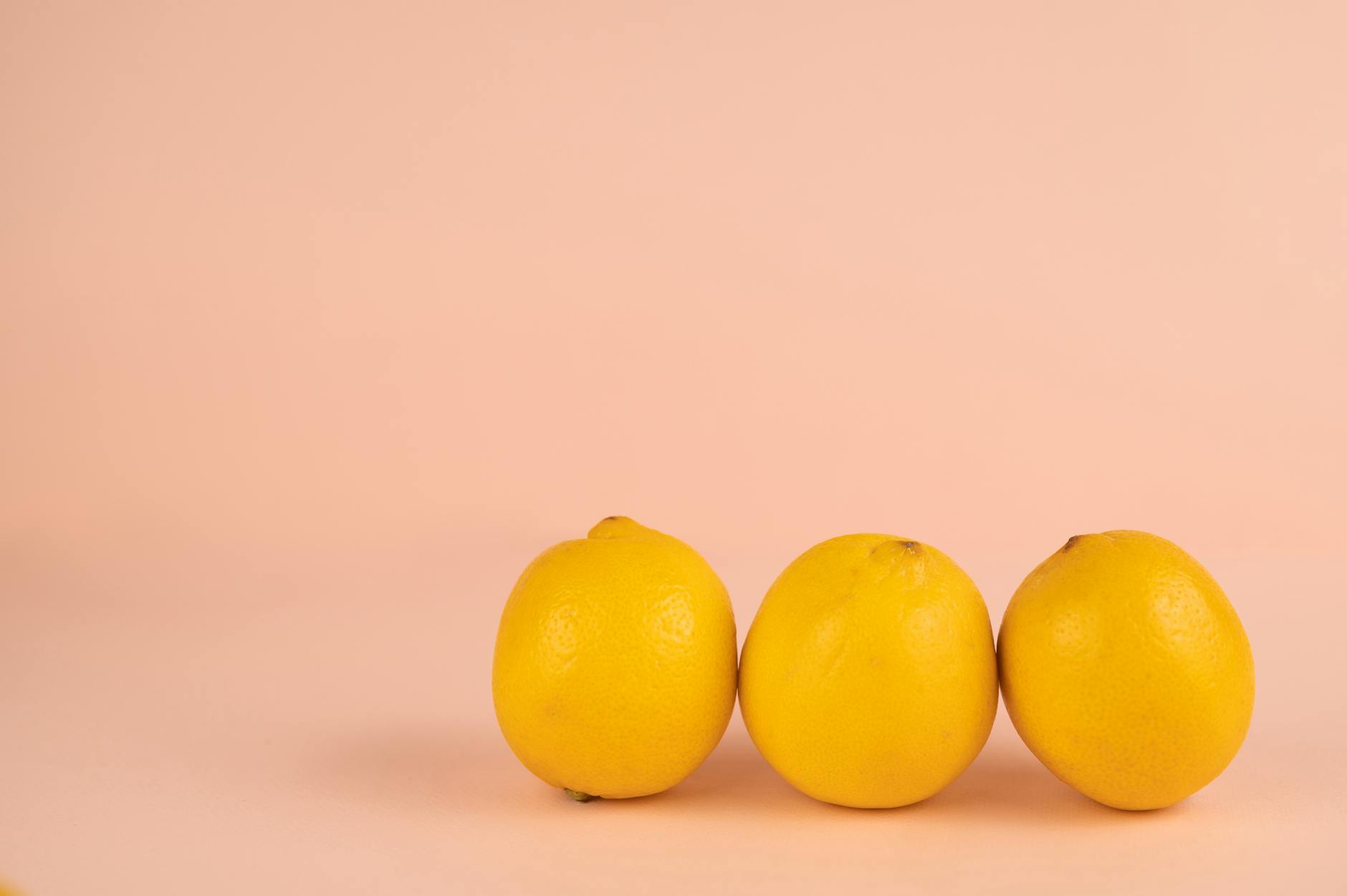 Bright yellow lemons arranged on a pastel green background